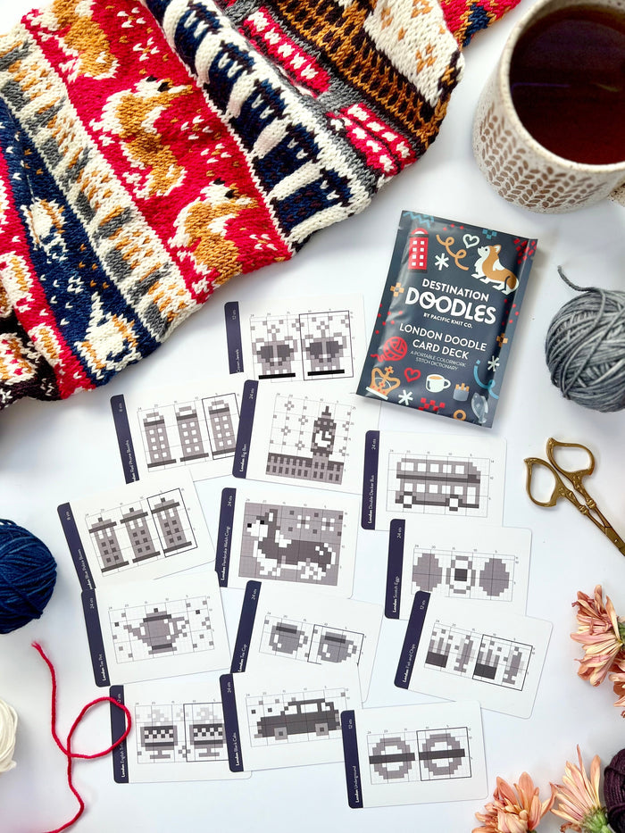 London Doodle chart cards scattered beside a corgi colorwork knit