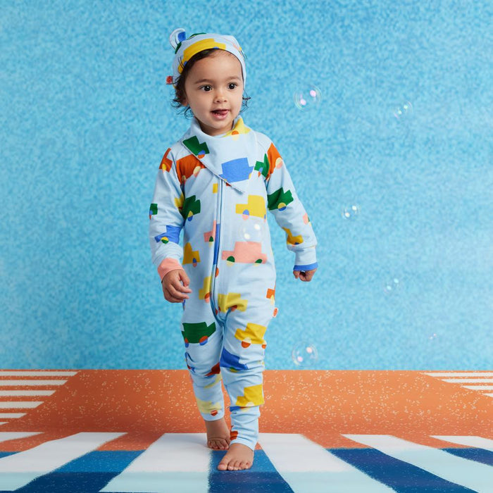 Child wearing a colorful onesie with a blue background