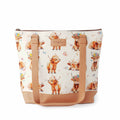 Maisy Highland Cow Mega Trinity Bag front view showing large zippered tote with watercolor highland cow print fabric, tan faux leather handles and base