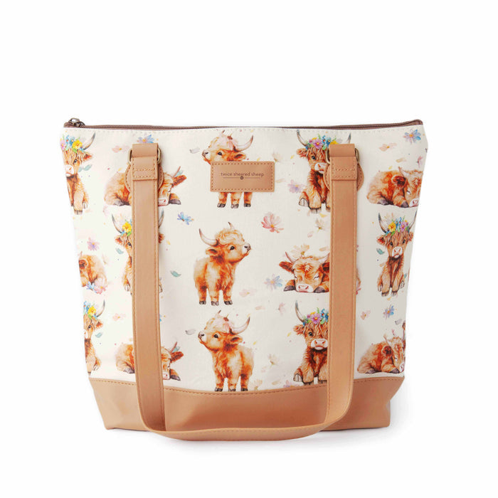 Maisy Highland Cow Mega Trinity Bag front view showing large zippered tote with watercolor highland cow print fabric, tan faux leather handles and base