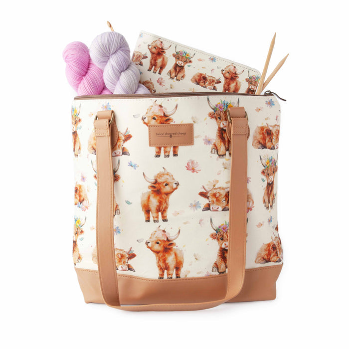 Close-up of Maisy Highland Cow Mega Trinity Bag fabric showing the watercolor highland cow and floral print detail with tan leather trim