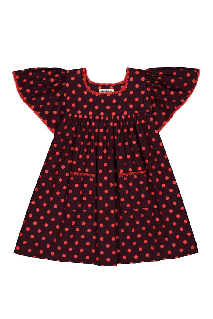A toddler girl's dress featuring a dark red base with a red-orange polka dot pattern, ruffled cap sleeves, and a smocked neckline, shown against a plain white background.