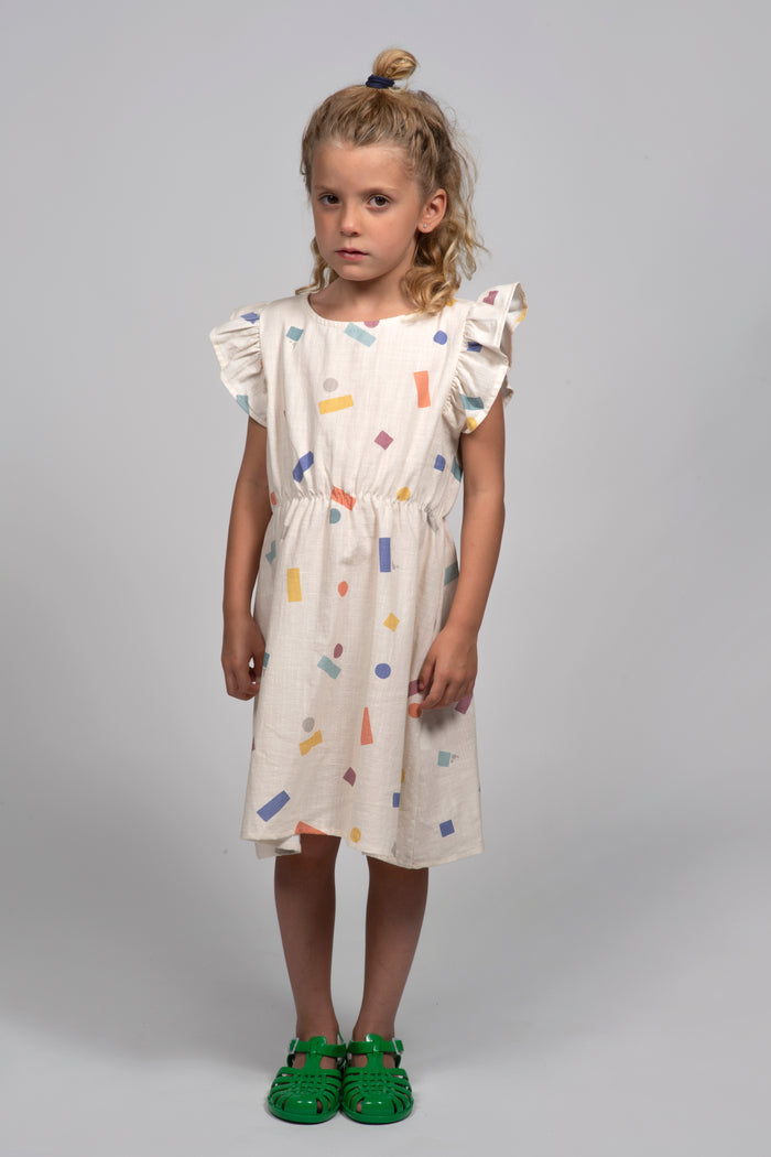 Young girl wearing a colorful dress on a gray background