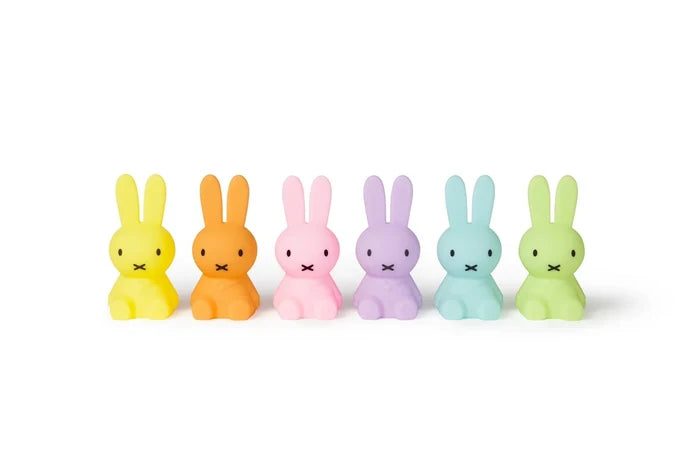 Six small bunny figurines in pastel colors arranged in a row on a white background. The colors are yellow, orange, pink, lavender, light blue, and light green.