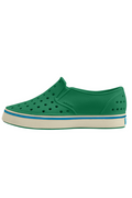Green slip-on shoe with white sole on a white background