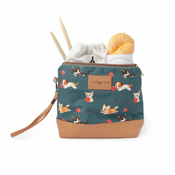 Cats and Dogs Mini Trini Bag filled with a yellow yarn ball, white drawstring pouch, and bamboo knitting needles showing the compact storage capacity