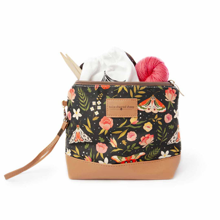 Night Forest Mini Trini Bag filled with a white yarn skein, pink yarn ball, and bamboo knitting needles showing the compact storage capacity