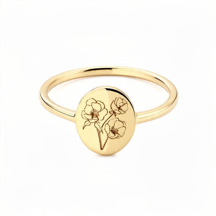 Delicate gold signet ring on pure white background with engraved botanical flower bouquet on oval disc, thin polished band, minimalist floral jewelry