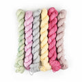 Six mini yarn skeins in pastel Spring Bouquet colors: mint, lilac, gray, butter, rose, and blush