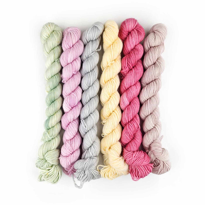 Six mini yarn skeins in pastel Spring Bouquet colors: mint, lilac, gray, butter, rose, and blush