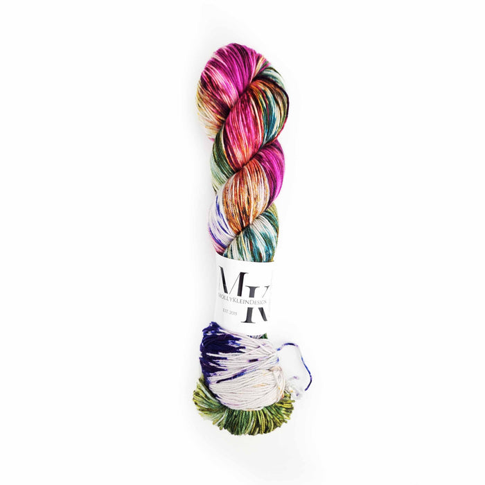 Skein of Molly Klein Fields in Bloom fingering weight yarn in vivid magenta, teal, green, and purple variegated dye