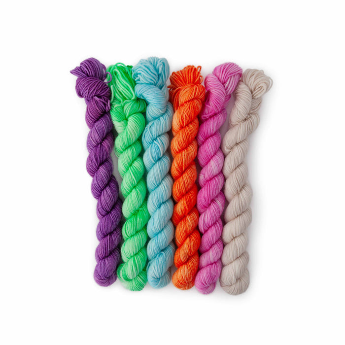 Six mini yarn skeins in purple, green, blue, orange, pink, and cream Dino Disco colorway