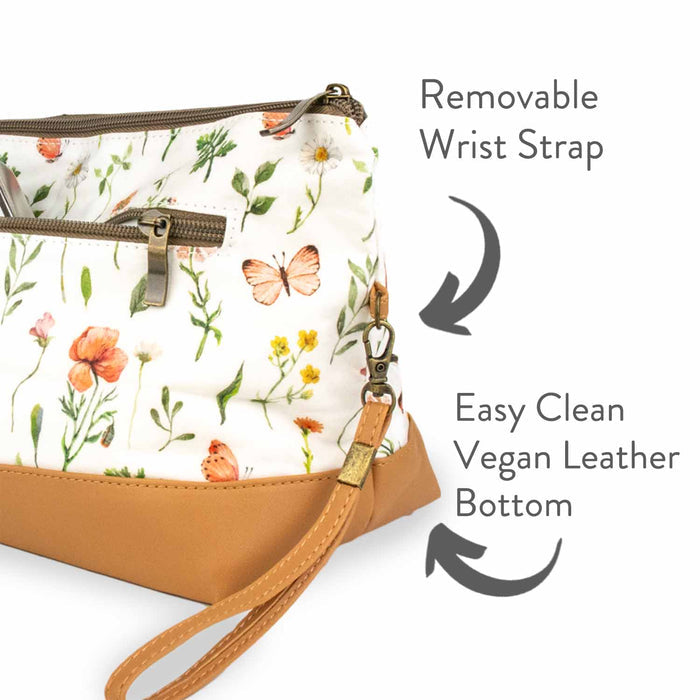 Side view of Mountain Meadow Trinity Bag showing the removable wrist strap clip and easy-clean vegan leather bottom with labeled callouts