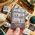 Hand holding the brown Music Doodle Card Deck by Pacific Knit Co tuckbox
