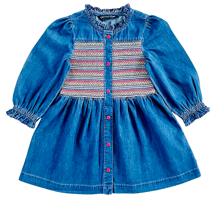 A blue denim baby dress with long puff sleeves, a smocked button-front bodice, and a colorful striped pattern across the chest, shown on a plain white background.