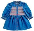 A blue denim baby dress with long puff sleeves, a smocked button-front bodice, and a colorful striped pattern across the chest, shown on a plain white background.