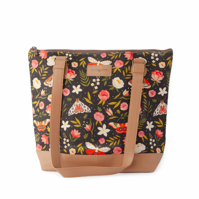 Night Forest Mega Trinity Bag front view showing the dark floral and moth print cotton canvas with pink peonies, white moths, and red atlas moths on a black background with tan vegan leather bottom and straps