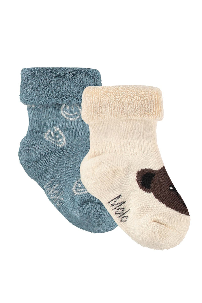 Two baby socks, one blue and one beige with brown accents, on a white background.