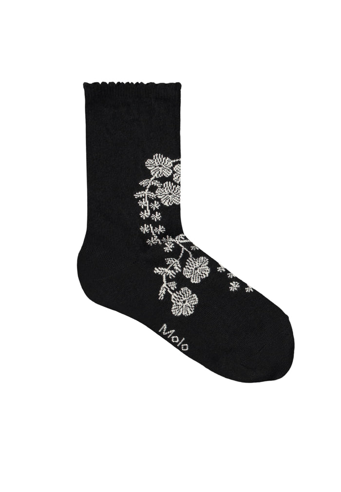 Black sock with white floral design on a white background