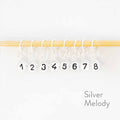 Silver melody clip style numbered stitch markers 1 through 8 with number beads hanging from bamboo knitting needle