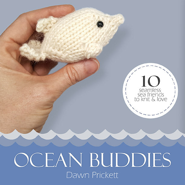 Ocean Buddies ebook cover by Dawn Prickett showing hand holding tiny knitted whale with 10 seamless sea friends to knit