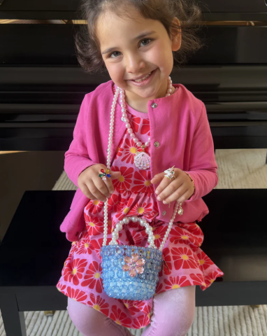 child wearing beaded purse