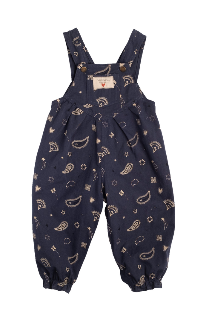 A pair of navy blue baby overalls with a beige paisley and star pattern, featuring elasticated cuffs and a front bib pocket, shown flat on a white background.