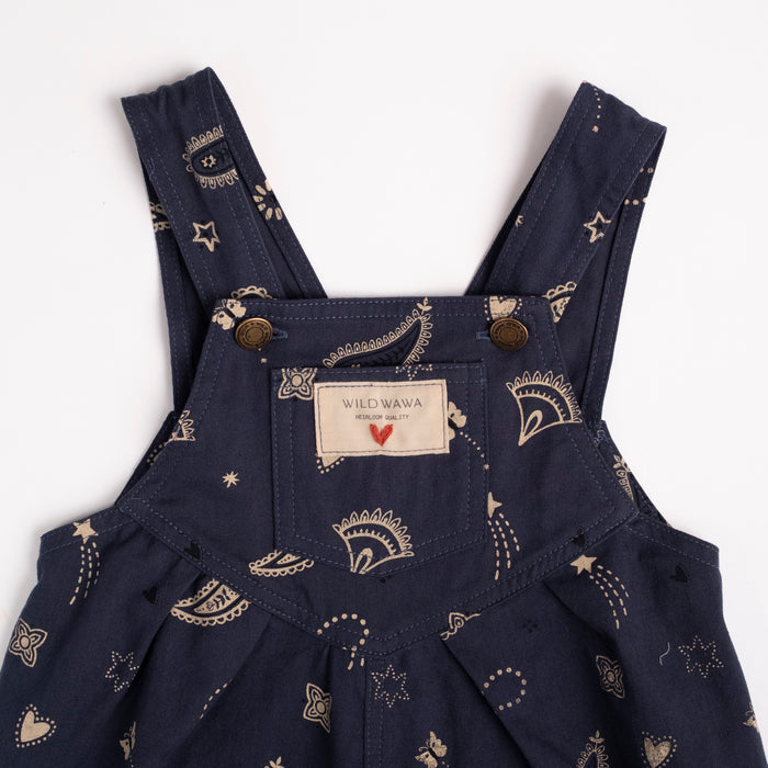 Navy blue overalls with bandana pattern and visible brand label on a white background