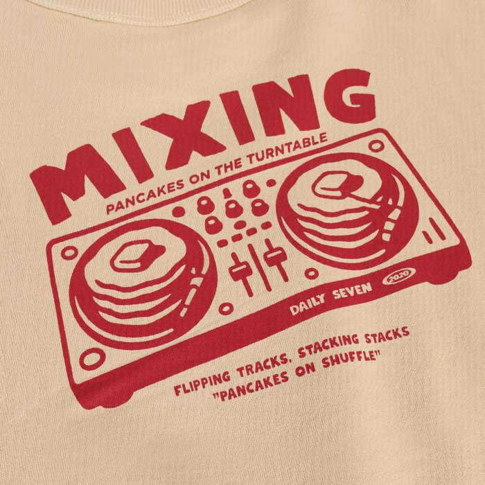 zoomed in view of red printed graphic on beige shirt