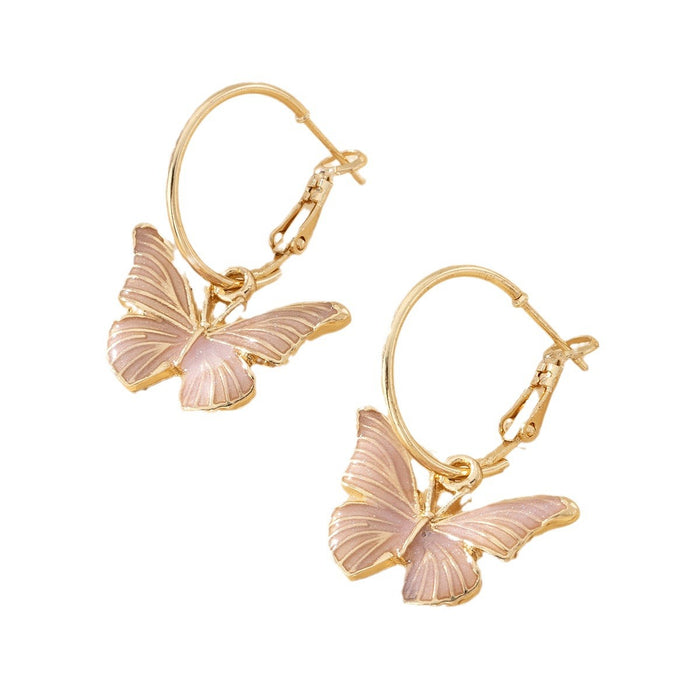 Pair of gold hoop earrings featuring delicate pink enamel butterfly charm pendants against a plain white background
