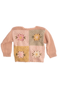 A pink knit sweater with four colorful crocheted granny square panels on the front, displayed against a plain white background.