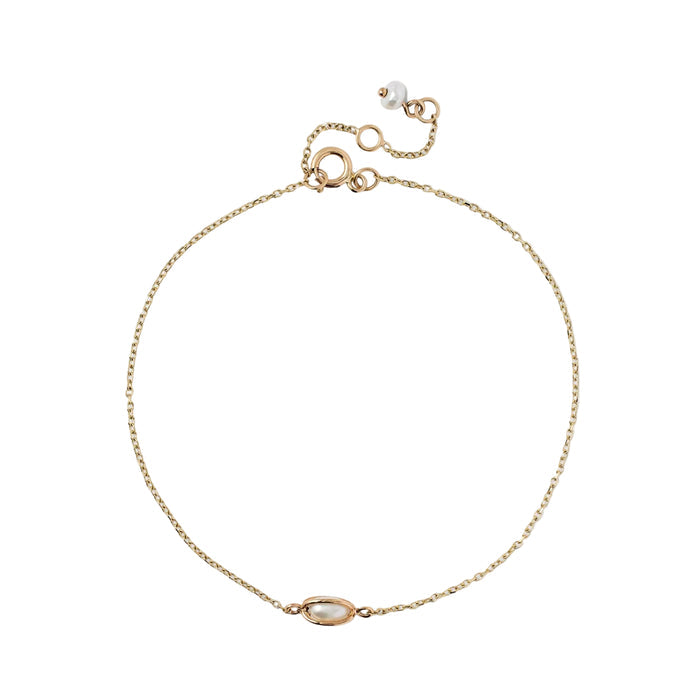 Fine gold-tone cable chain bracelet featuring a horizontal oval-set pearl charm and a small pearl dangle on the adjustable clasp, isolated on a white background.
