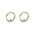 Pair of irregular wavy gold hoop earrings featuring a single white pearl accent in a minimalist organic design.