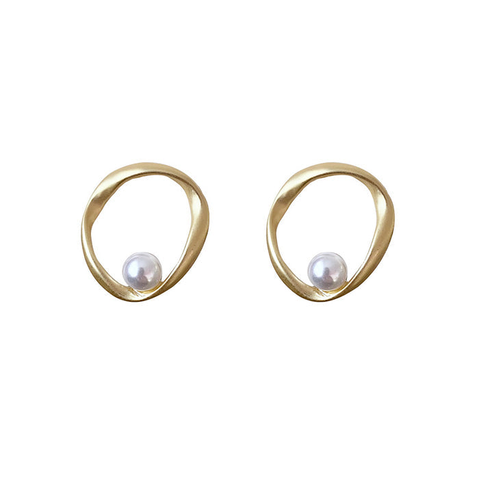 Pair of irregular wavy gold hoop earrings featuring a single white pearl accent in a minimalist organic design.