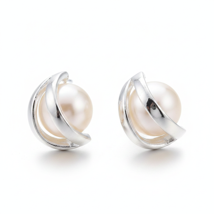 Pair of silver-tone stud earrings featuring a large cream-colored round pearl cradled in a modern, open-circle orbital frame on a clean white background.