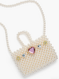 Heart-shaped pearl clutch with gemstone accents on a white background
