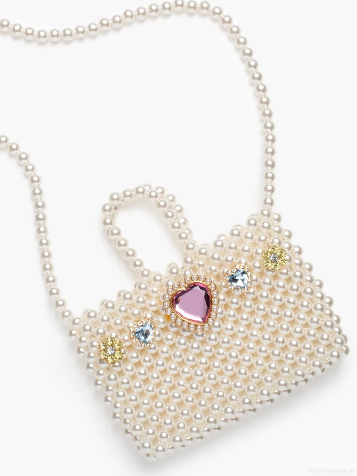 Heart-shaped pearl clutch with gemstone accents on a white background