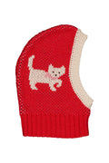 A red knit balaclava with a cream-colored knitted side panel and a knitted cat motif on the front, shown against a plain white background.