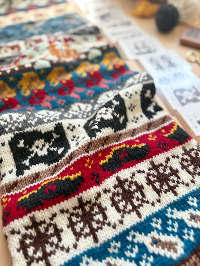 Close-up of a Pirate Doodle colorwork knit with skull and flag motifs