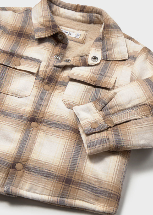 Folded plaid shirt on a light gray background