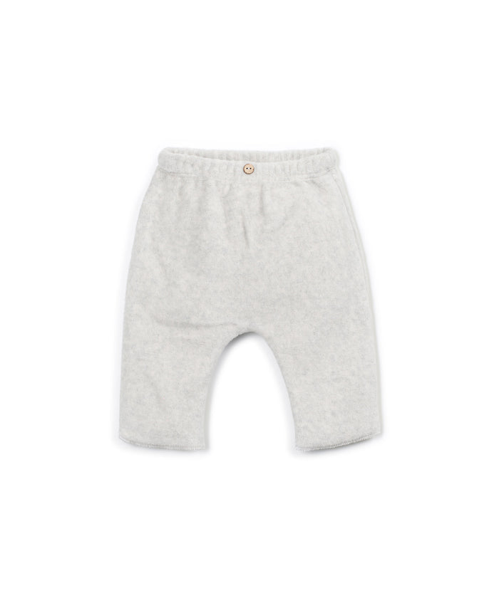light gray fleece baby pants with decorative wooden button and elastic waist on white background