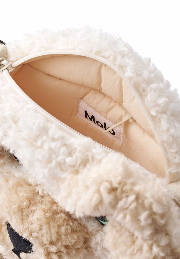 Close-up of a fluffy white bag with a visible brand label on a white background