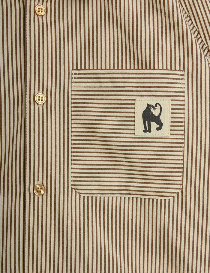 Close-up of a striped shirt with a small logo on the chest pocket.
