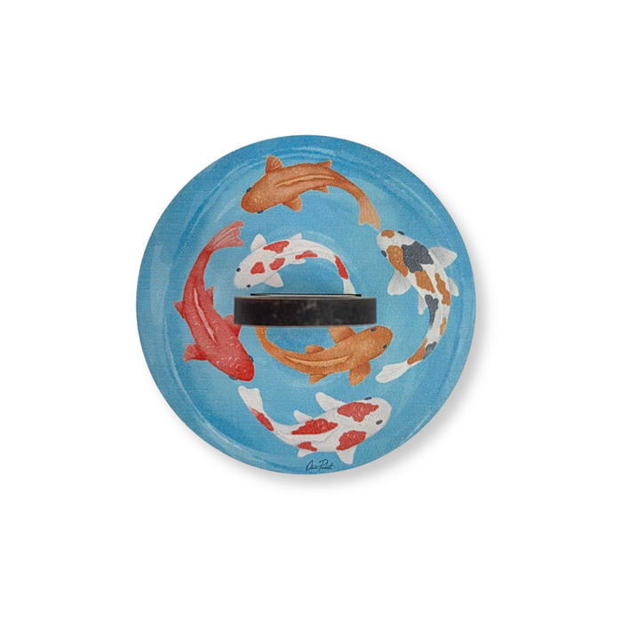 Top-down view of the Koi Fish Yarn To Go Carousel showing the colorful koi pond artwork and center spindle opening