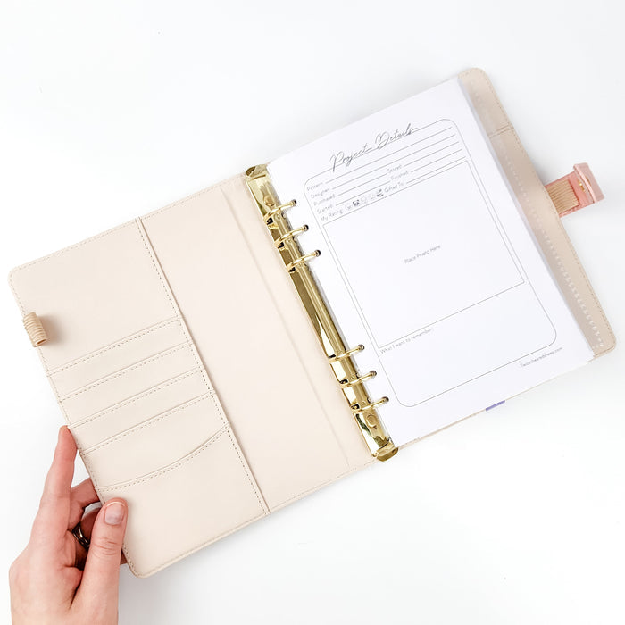 Spring Floral Project Journal Planner opened flat showing cream faux leather interior with card slots on the left and Project Details page with gold six-ring binder and pink snap closure