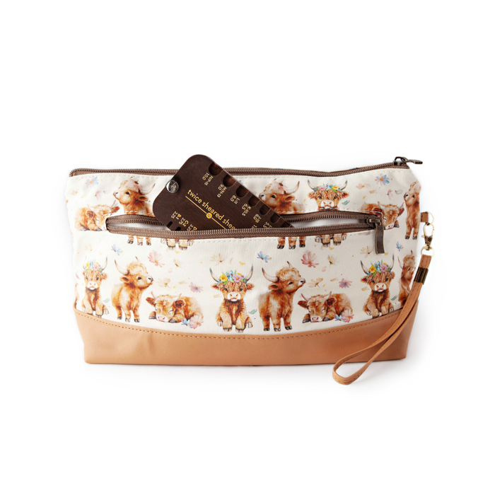Stitch Scout Multi-Tool tucked into a highland cow print zippered project bag showing its portable size