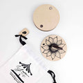 Sunflower Yarn To Go Carousel disassembled showing wooden sunflower base plate, plain top plate, ladybug peg, and drawstring bag