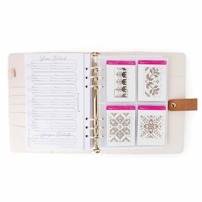 Project journal open showing yarn details page alongside card protector sleeve holding four Spring Florals colorwork chart cards