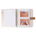 Pink project journal open showing a printed knitting pattern with step-by-step photos inside a clear page protector sleeve