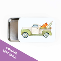 Slide top stitch marker storage tin with a watercolor green pickup truck carrying pumpkins and gourds, with a Coming Sept 28th banner